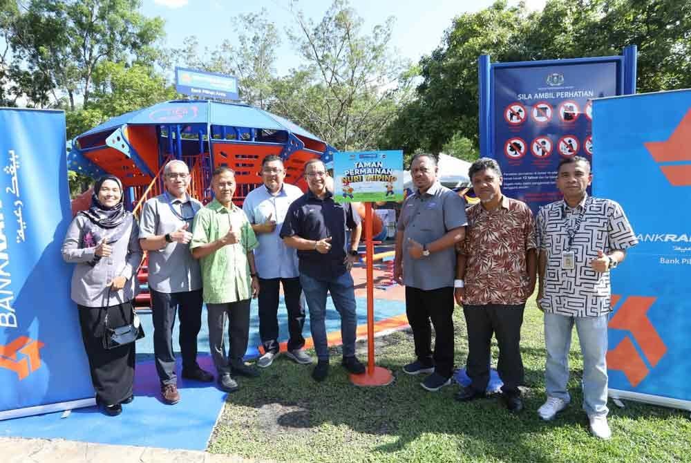 Ketua Pegawai Pemasaran dan Komunikasi, Nizam Sani (lima dari kiri) bergambar di Taman Permainan Nuri Bank Rakyat pada Rabu.