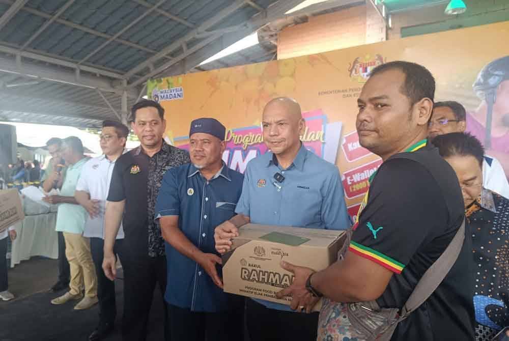 Armizan (tengah) menyampaikan bantuan berupa barangan kepada penerima Program Jualan Rahmah Madani Mega Negeri Terengganu.