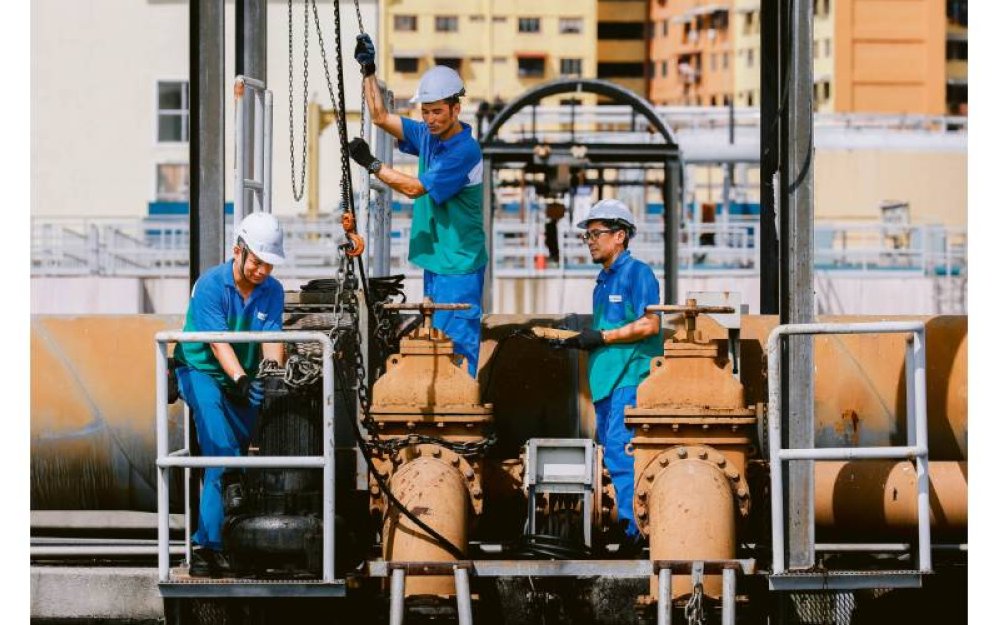 Tiga orang pekerja IWK sedang melakukan kerja- kerja penyelenggaraan.