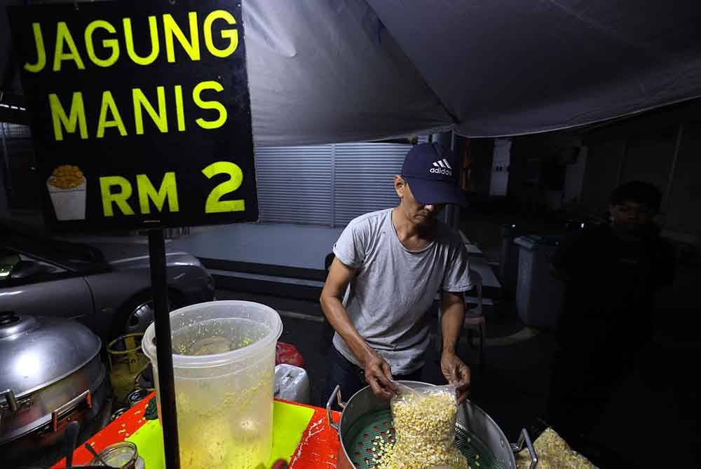 Meskipun ramai peniaga terpaksa menaikkan harga jualan berikutan kenaikan harga bahan mentah, namun seorang peniaga jagung masih kekal menjual secawan jagung rebus dengan harga RM2. Foto Bernama