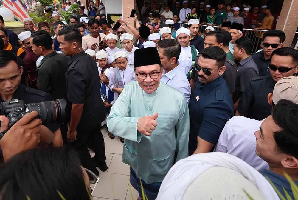 Anwar beramah mesra dengan jemaah selepas menunaikan solat jumaat di Masjid Darussalam Puchong Kampung Batu 13 1/2 Puchong hari ini. - Foto: Bernama