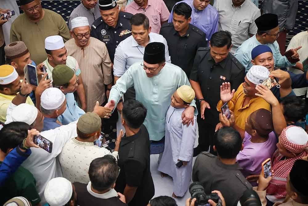 Anwar beramah mesra dengan jemaah selepas menunaikan solat jumaat di Masjid Darussalam Puchong Kampung Batu 13 1/2 Puchong hari ini. - Foto: Bernama