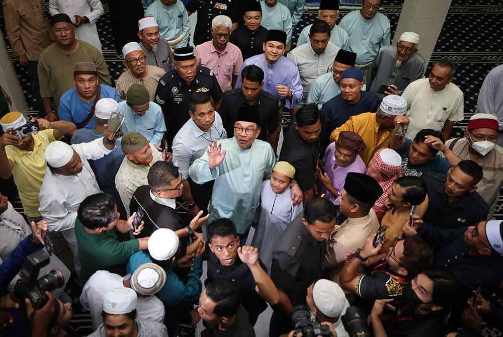 Anwar beramah mesra dengan jemaah selepas menunaikan solat jumaat di Masjid Darussalam Puchong Kampung Batu 13 1/2 Puchong hari ini. Foto Bernama