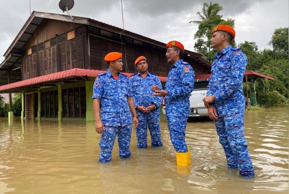 Aminurrahim (dua dari kanan) semasa meninjau kawasan banjir di Kampung Chegar, Anak Bukit, Alor Setar pada Sabtu.