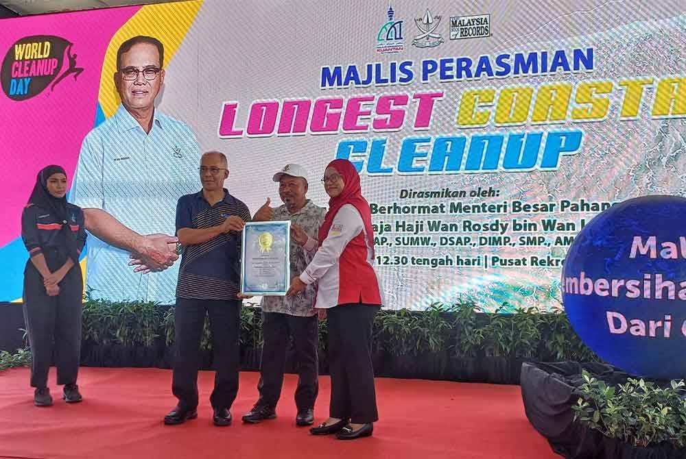 Siti Hajar (kiri) menyampaikan penganugerahan Malaysia Book Of Record: Longest Coastal Clean Up yang disaksikan Shafik Fauzan pada majlis itu di Pusat Rekreasi Air, Balok pada Ahad.