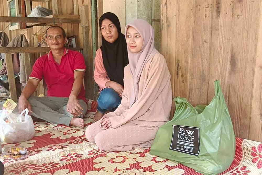 Nurul Hazwanie (kanan) bersama ibu bapanya.