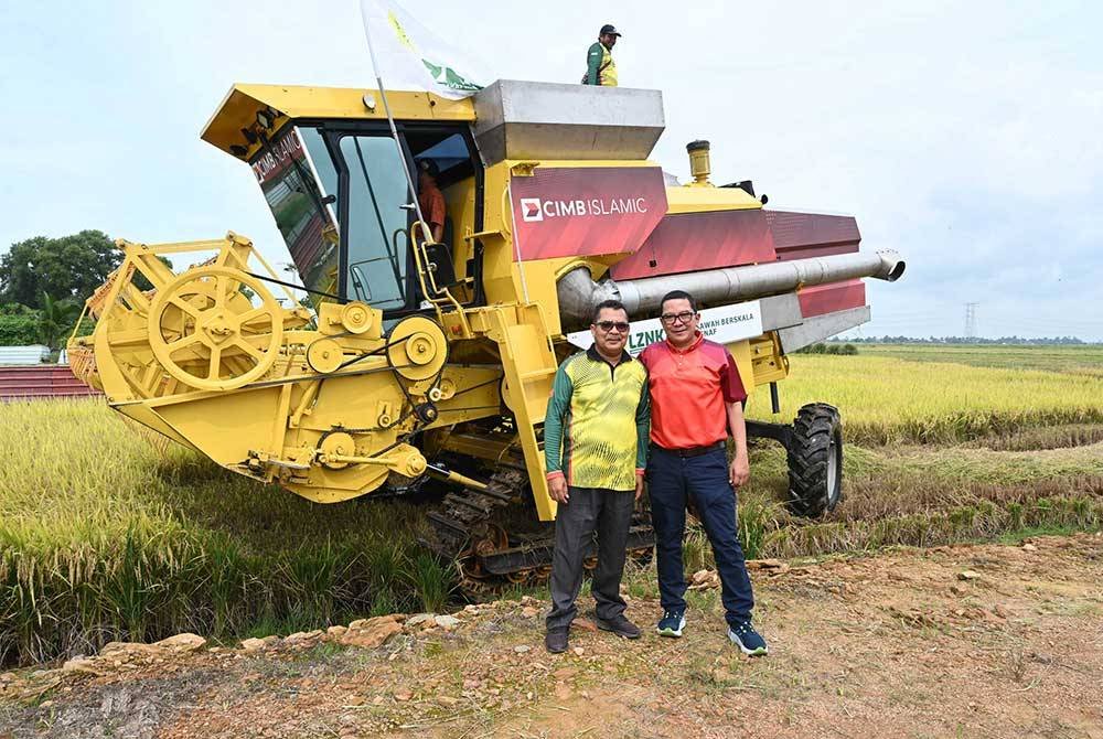 Ahmad Shahriman (kanan) bersama Syeikh Zakaria (kiri) dalam majlis penyerahan jentera penuai padi di Yan, Kedah.