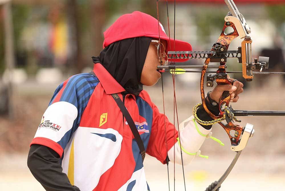 Pemanah Para Sukma Wilayah Persekutuan Nursufiah Mohd Nizam melakukan panahan menggunakan mulut dalam acara memanah Compound di Lapang Sasar Memanah Petra Jaya Kuching, pada Isnin. Foto Bernama