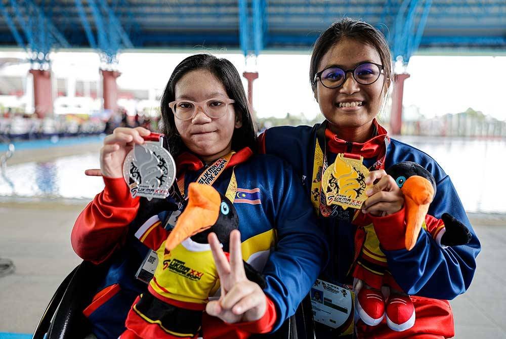 Perenang para Kuala Lumpur, Asyiil Raziin Razman (kanan), bergambar bersama pingat emas setelah menjuarai acara 100M Gaya Bebas Wanita S14, sementara Naznyn Nazlee Hadanee (kiri) bergambar bersama pingat perak yang dimenanginya dalam acara 100M Gaya Kuak Dada Wanita SB4-SB6, pada temasya Para Sukan Malaysia (Para SUKMA) Sarawak 2024, pada Isnin. Foto Bernama