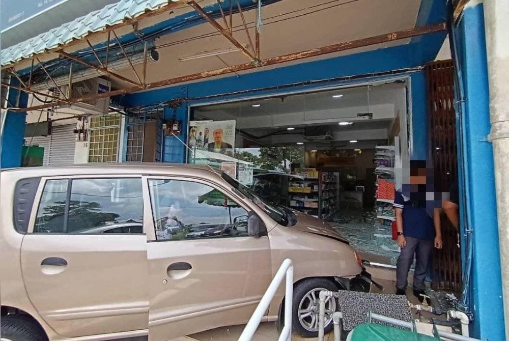 Kereta dipandu seorang wanita warga emas merempuh sebuah farmasi di Jalan Lingkaran 2, Taman Sri Lambak, Kluang pada Isnin. Foto IPD Kluang