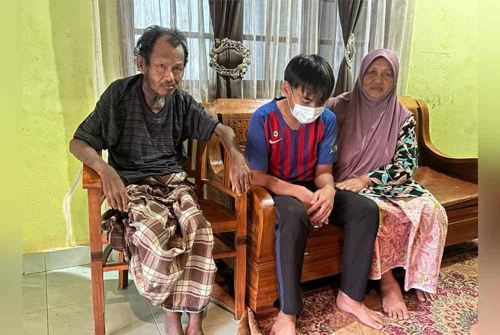 Ahmad Azimi (tengah) dan Zulkifli (kiri) dikujungi saudaranya, Hazimah Kotok, 66, di rumah mereka di Tanah Merah.