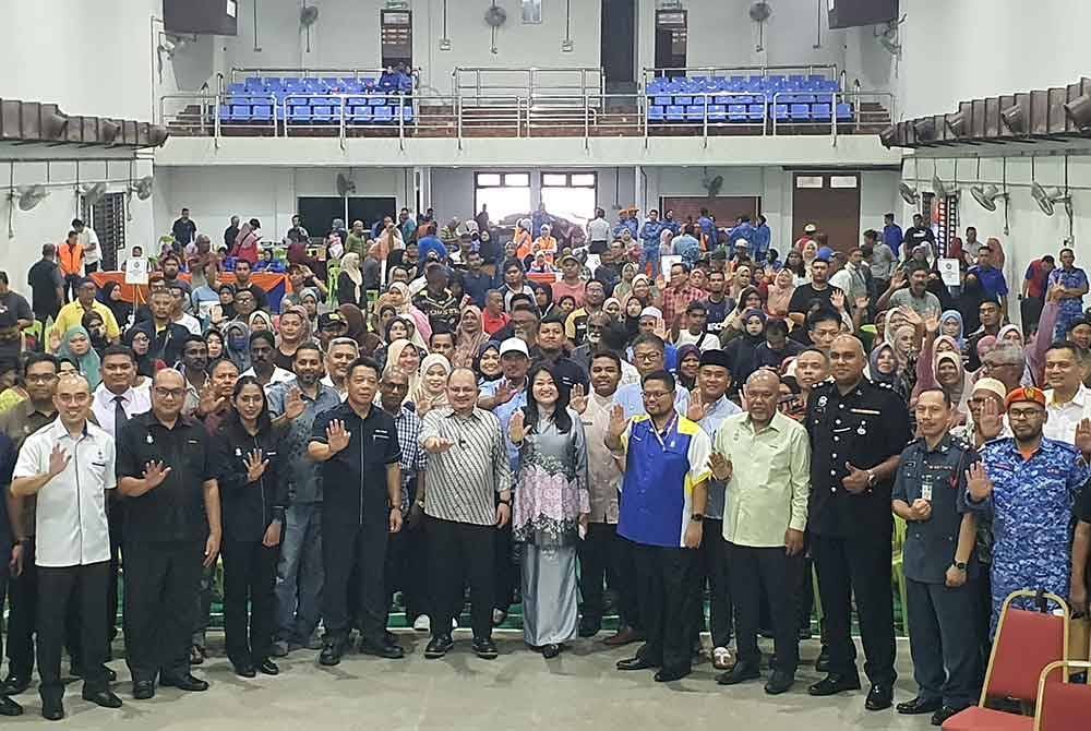 Shamsul Iskandar (tengah) bergambar bersama penerima sumbangan bencana di Dewan Sungai Dua, pada Selasa.