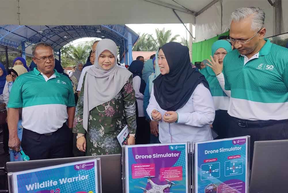 Fadhlina (dua dari kiri) melawat salah satu reruai semasa Program Yayasan Petronas Powering Knowledge: Stem Hub Program Duta Guru di Pusat Kegiatan Guru (PKG) Tanjong Karang di sini pada Selasa.