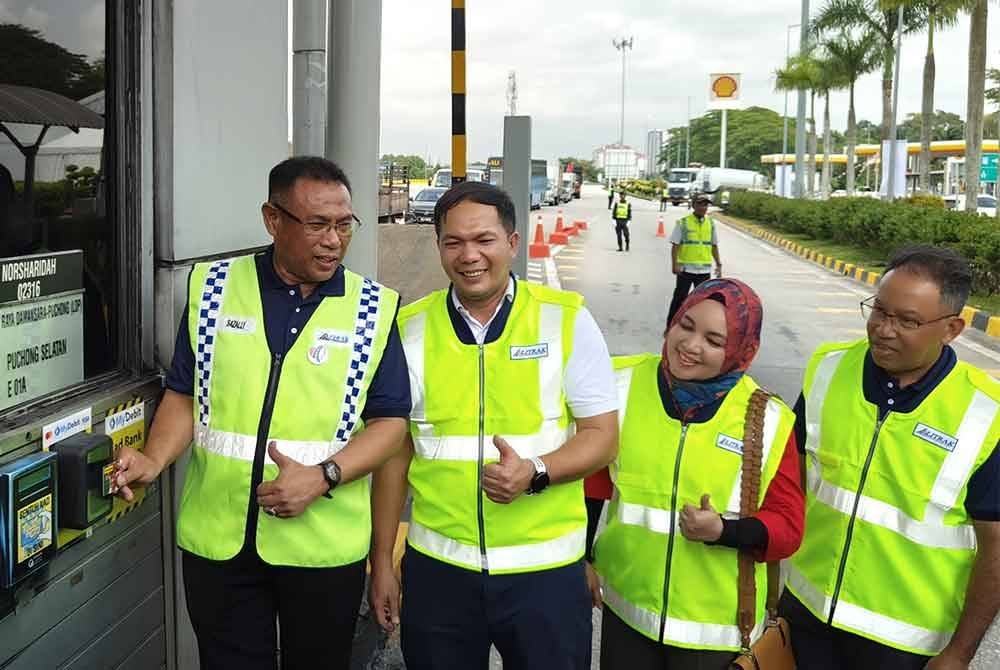 Sazally (kiri) menyempurnakan gimik pelancaran Sentuhan Ikhlas di Plaza Tol Puchong Selatan di sini pada Selasa.