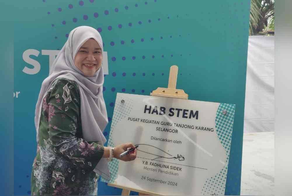 Fadhlina menandatangani plak perasmian semasa Program Yayasan Petronas Powering Knowledge: Stem Hub Program Duta Guru di Pusat Kegiatan Guru (PKG) Tanjong Karang pada Selasa.