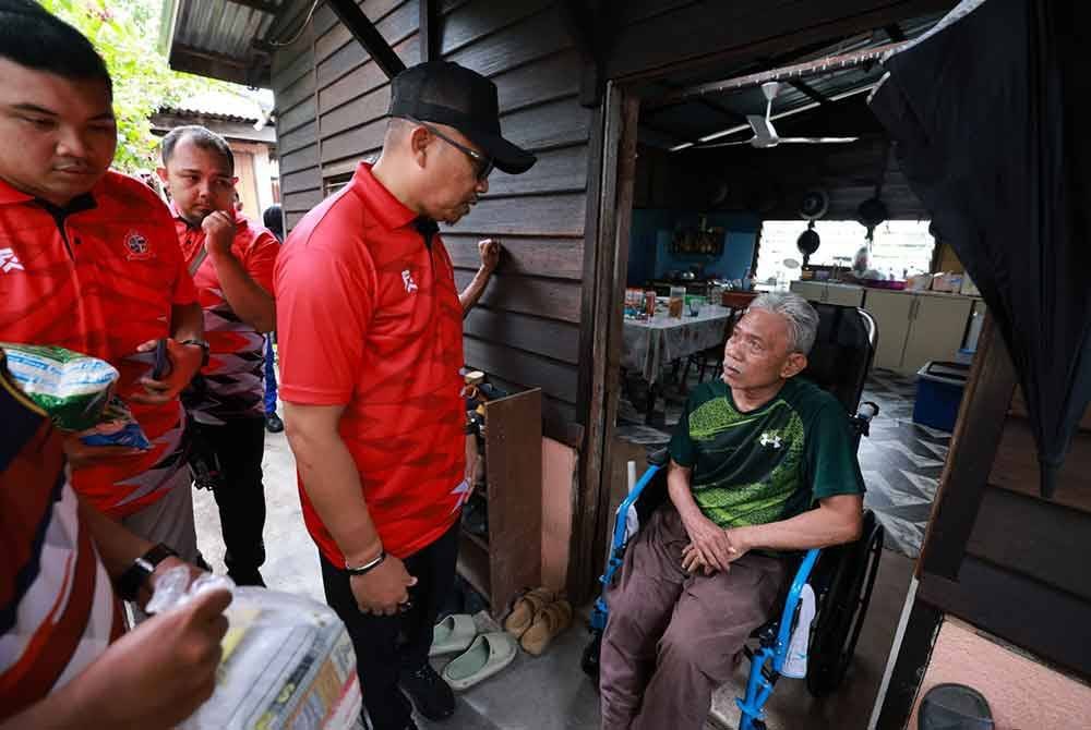 Ismasuhaimi (tiga dari kiri) menyantuni seorang mangsa banjir, Yatim Mohd Akhir yang diserang strok sejak enam tahun lalu.