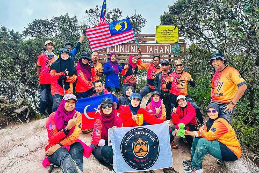 Mahani (belakang, enam dari kiri) bersama rakan pendaki yang berjaya menawan puncak Gunung Tahan pada sambutan Hari Malaysia baru-baru ini.