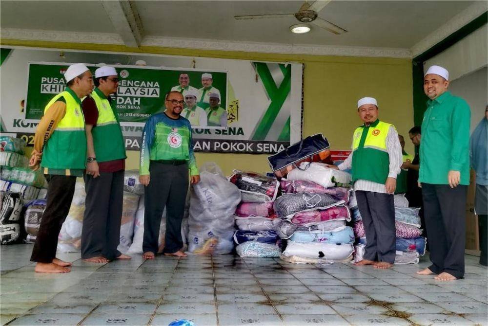 Ahmad (dua dari kanan) memeriksa sumbangan barangan untuk diagihkan kepada mangsa banjir.