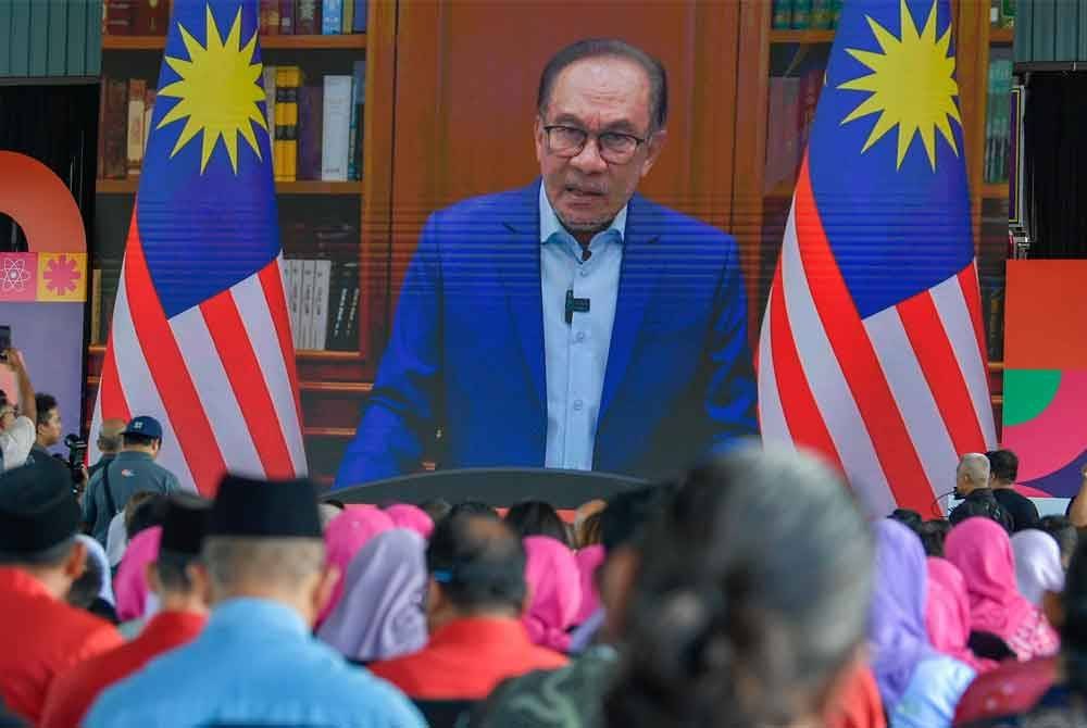 Orang ramai menyaksikan rakaman ucapan Perdana Menteri, Datuk Seri Anwar Ibrahim yang disiarkan pada Majlis Pelancaran Program Anak Kita: Semarak Potensi Malaysia di Sekolah Kebangsaan Rasa pada Jumaat. Foto Bernama