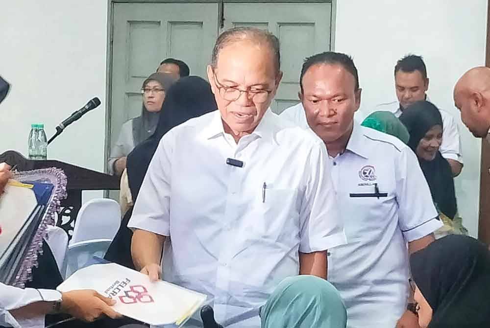 Wan Rosdy (tengah) ketika menyerahkan surat hak milik tanah kepada penerima di Dewan Dayo&#039; Zaharuddin Abu Kasim, Temerloh pada Jumaat.