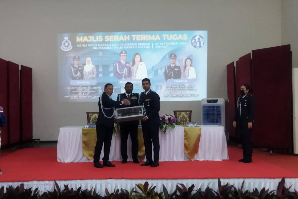 Wan Kamarul Azran (kiri) menyerahkan tongkat kuasa kepada Shan Gopal dalam Majlis Serah Terima Tugas di Ibu Pejabat Polis Daerah (IPD) Sepang pada Jumaat.