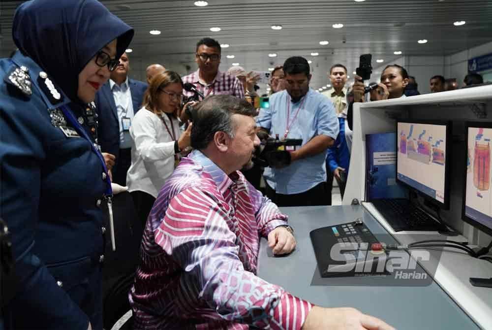 Amir Hamzah (duduk) bersama Anis Rizana (kiri) melihat pengimbas bagasi baharu JDKM di Lapangan Terbang Antarabangsa Kuala Lumpur (KLIA) pada Jumaat. Foto Sinar Harian/ROSLI TALIB