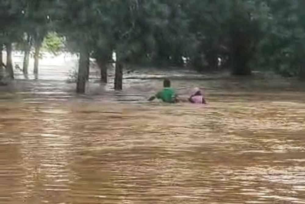 Rakaman video yang tular menunjukkan kedua beranak terbabit cuba meredah arus banjir yang deras.