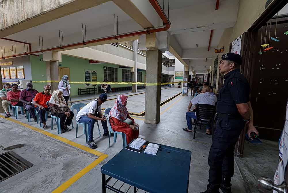 Orang ramai menunggu giliran untuk menunaikan tanggungjawab mengundi pada PRK DUN Mahkota di Sekolah Menengah Kebangsaan Seri Perdana hari ini. Foto Bernama