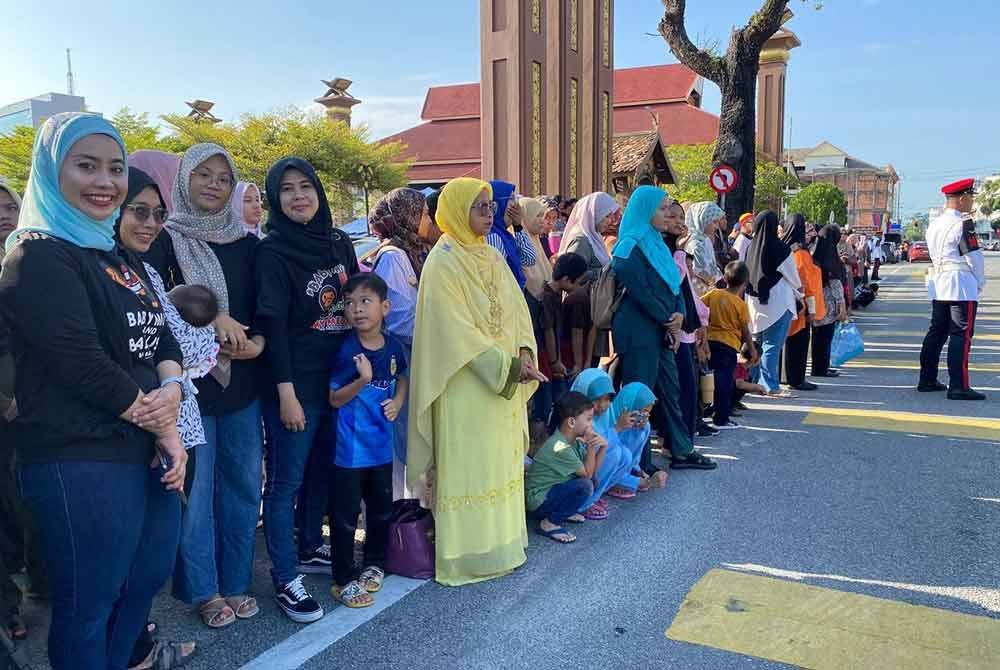 Nik Echah (kiri) bersama ahli keluarganya hadir ke lokasi sambutan seawal jam 7 pagi bagi memastikan mereka mendapat tempat di hadapan.