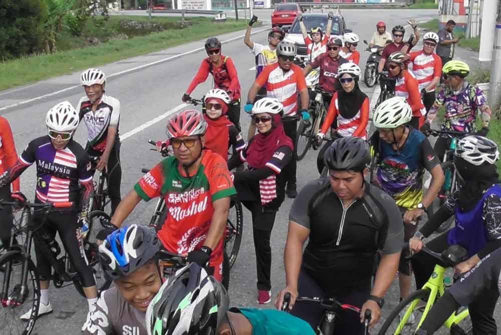 Zainol Fadzi (tengah) turut bersama-sama peserta di dalam program Kayuhan Hari Malaysia anjuran Pusat Khidmat ADUN Sungai Manik di Langkap pada Ahad.