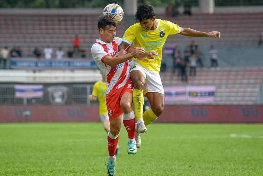 Pemain KL City, FC Sean Gan Giannelli (kiri) menanduk bola sambil diasak Muhammad Adib (kanan) pada perlawanan Liga Super antara KL City menentang Penang di Stadium Bola Sepak Kuala Lumpur hari ini.