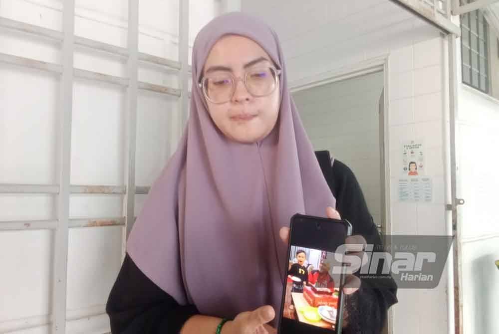 Farhana menunjukkan gambar Allahyarham Abu Zaini bersama anaknya.