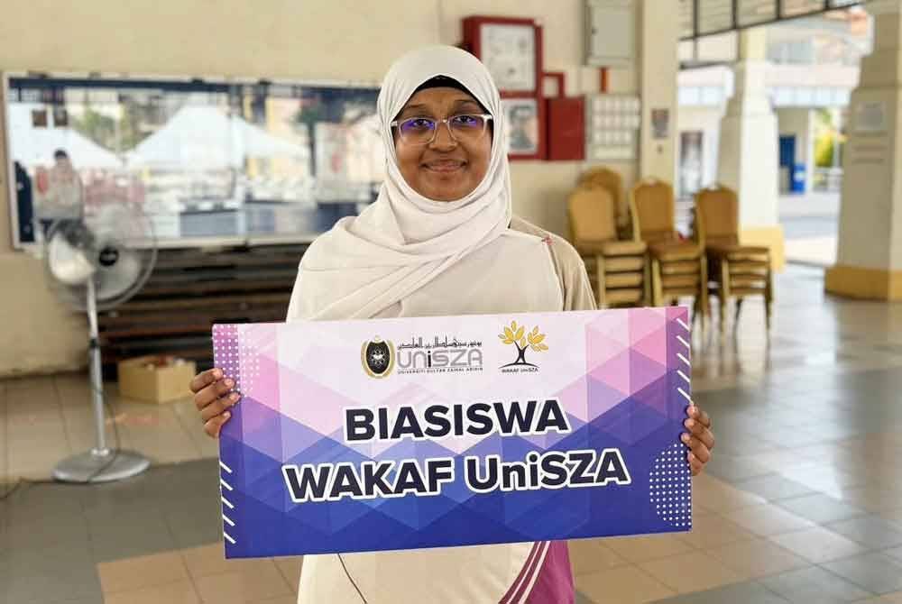 Noor Firdaws memegang plakad Biasiswa Wakaf UniSZA ketika ditemui pada Majlis Pendaftaran Pelajar Baharu Ijazah Sarjana Muda UniSZA Sesi Kemasukan 2024/2025, di Kampus Gong Badak, Kuala Nerus pada Ahad.