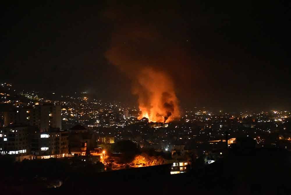 Asap tebal menjulang ke langit selepas serangan udara Israel melanda pinggir bandar Beirut.- AFP