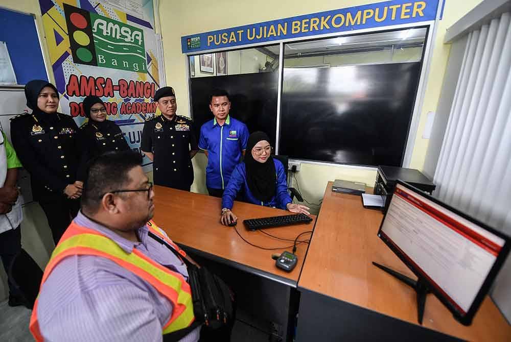 Aedy Fadly (tiga, kiri) memantau pendaftaran peserta dalam Program Khas Peralihan lesen kelas B2/B1 kepada kelas B di Akademi Memandu Shah Alam (AMSA) Bangi, pada Selasa. Foto Bernama