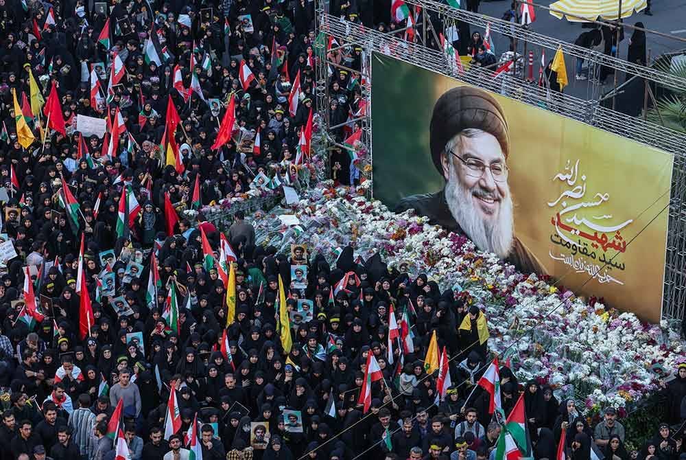 Rakyat Iran memberi penghormatan akhir ketika berhimpun di hadapan potret gergasi Nasrallah di Dataran Palestin pada Isnin. - Foto AFP