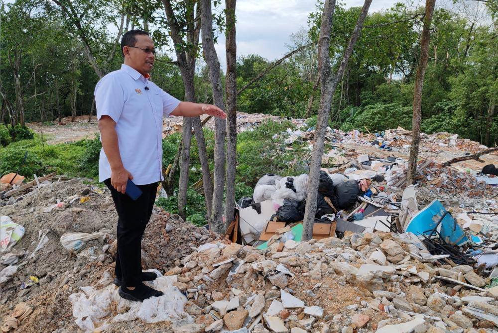 Suhaizan menujukkan tempat pembuangan sampah haram di Kampung Tuah Jaya, Taman Perling, Johor Bahru.