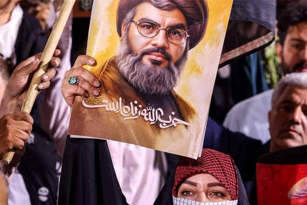 Hassan Jafar Qasir, menantu kepada pemimpin Hizbullah, Sayyed Hassan Nasrallah (poster) turut terbunuh dalam serangan udara Israel ke atas sebuah kediaman di kawasan Mazzeh Western Villas, Damsyik pada Rabu. AFP.