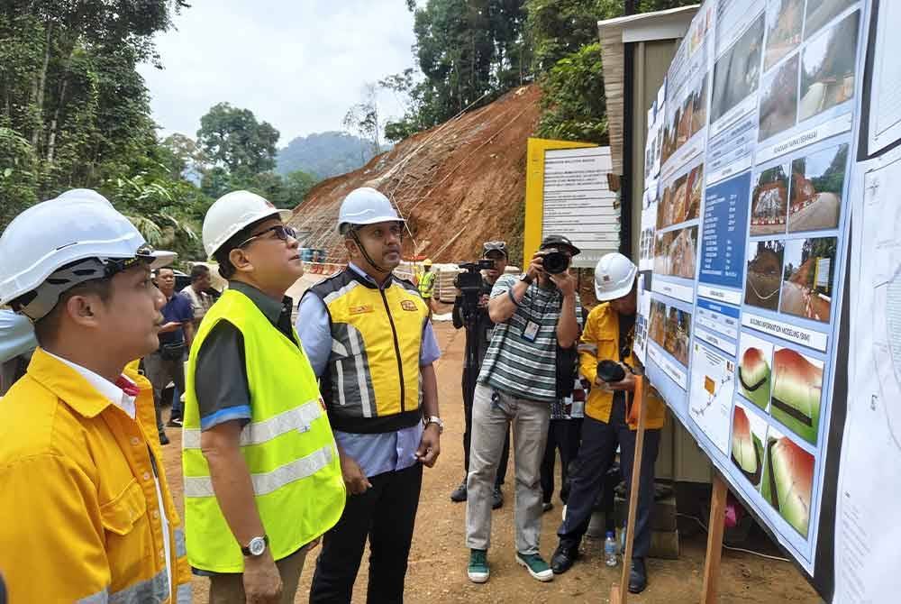 Izham (dua dari kiri) meninjau projek kerja-kerja pengukuhan cerun di Jalan Genting Peras.