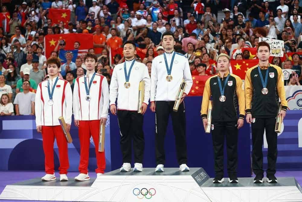 Aaron-Wooi Yik (kanan) menghadiahkan kontinjen Malaysia pingat pertama dari Olimpik Paris 2024. Foto OCM