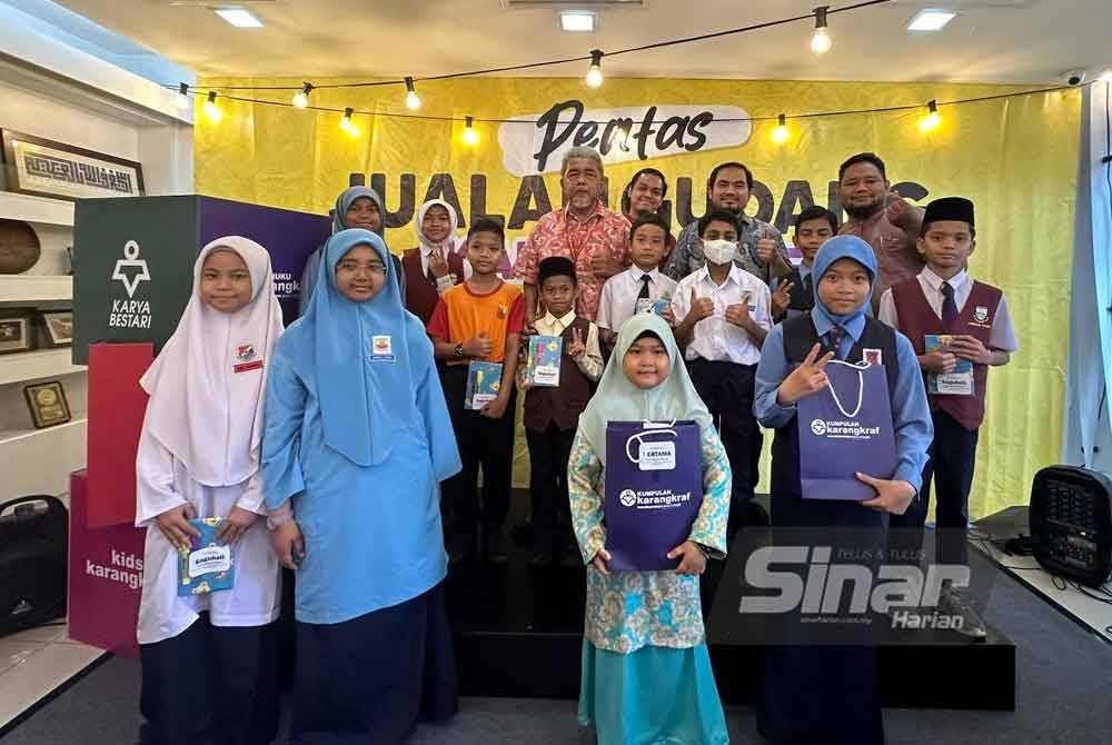 Peserta Pertandingan Hafazan sempena Jualan Gudang Karangkraf 2024 bergambar kenangan bersama Pengurus Kanan Tugas-Tugas Khas Karangkraf, Hashim Anang (tengah).