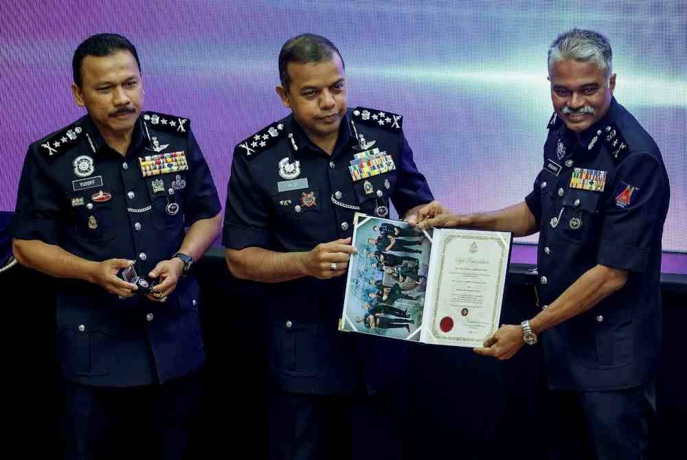 Ayob Khan (tengah) menyampaikan sijil lantikan sebagai Komander kepada Srikumar (kanan) pada Majlis Pelancaran Sel Jururunding PDRM di Dewan Theatrette, Menara 1 Bukit Aman pada Jumaat. Foto Bernama