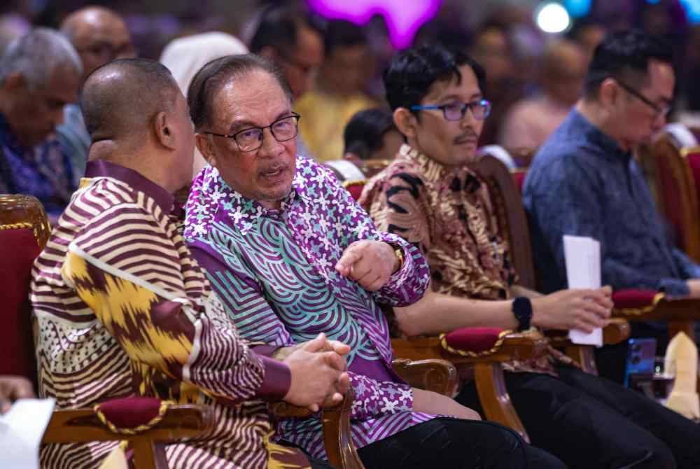 Anwar (dua dari kiri) berbincang bersama Saarani (kiri) pada majlis Syarahan Za&#039;ba Seabad Pemikir Kemiskinan dan Hari Akademia Negara di Universiti Pendidikan Sultan Idris (UPSI) hari ini. Foto Bernama