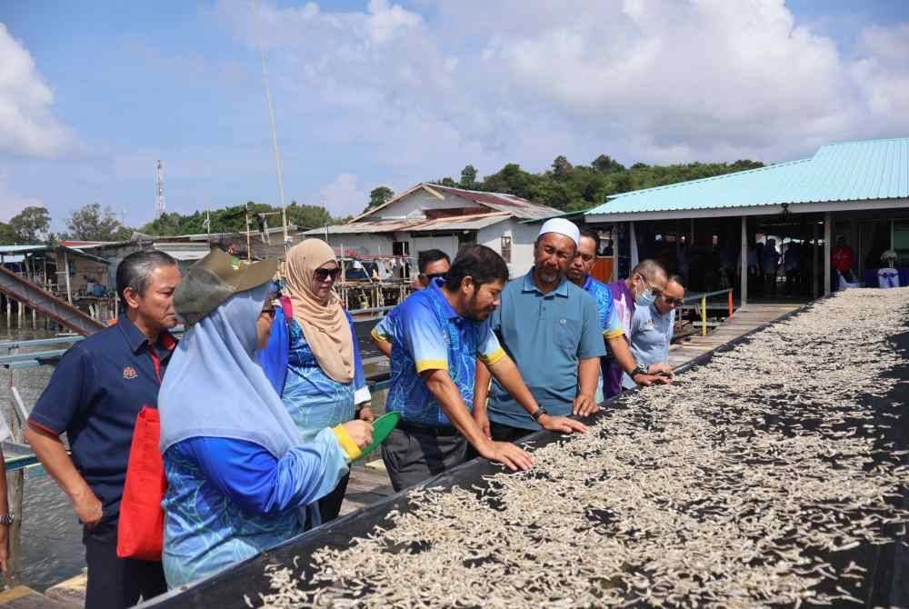 Mohd Uzir (lima dari kanan) ketika mengadakan lawatan ke perusahaan ikan bilis di Kampung Bebuloh Laut sempena Program Lawatan Kerja Pesuruhjaya Banci Pertanian di Wilayah Persekutuan Labuan.