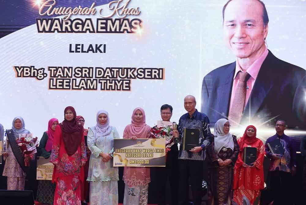 Noraini (tiga dari kiri) menyampaikan Anugerah Khas Warga Emas Kategori Lelaki kepada Lam Thye (dua dari kanan) pada Sambutan Hari Warga Emas Peringkat Kebangsaan di PICC hari ini. - Foto: Bernama