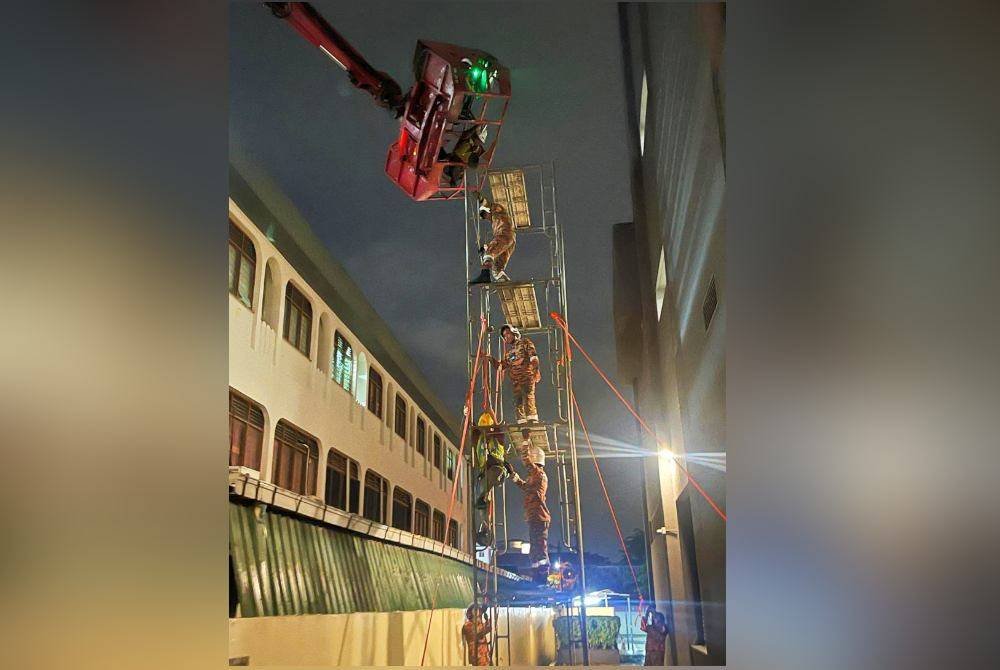 Anggota bomba menjalankan operasi menyelamat tiga pekerja lelaki yang tersangkut atas kren yang rosak pada ketinggian enam meter di sebuah bangunan di Ipoh pada Sabtu. Foto JBPM Perak