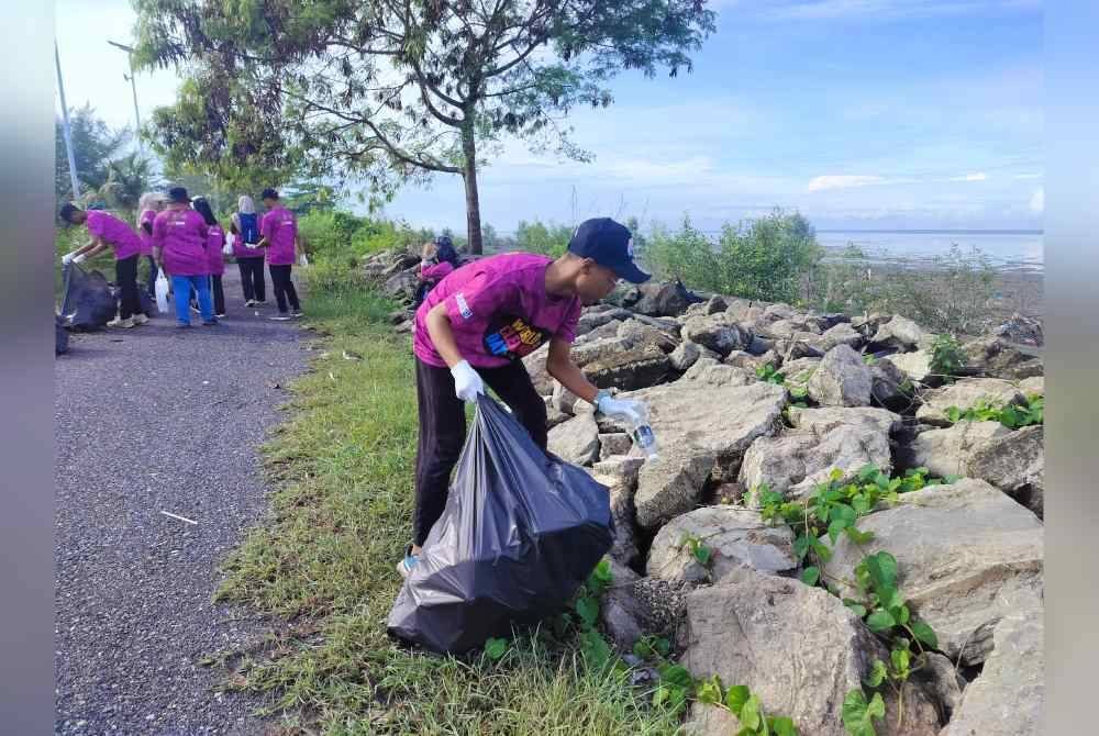 Sukarelawan sedang mengutip sampah di pesisiran pantai Kurong Tegar di ini.