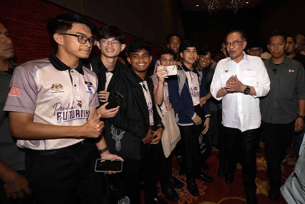 Anwar (dua dari kanan) beramah mesra bersama para pelajar selepas melancarkan Bulan Bahasa Kebangsaan 2024 di Pusat Konvensyen Ipoh pada Ahad. Foto Bernama