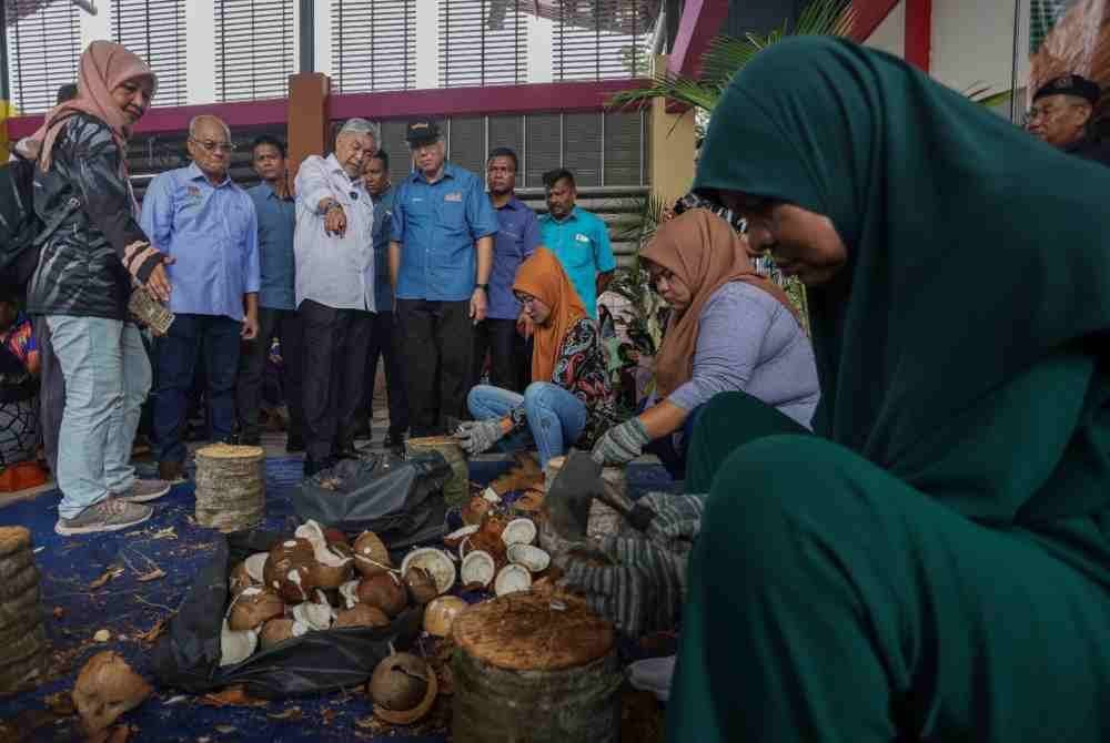 Ahmad Zahid (tiga dari kiri) menyaksikan aktiviti berkaitan kelapa yang diadakan sempena program Kelapa Fest yang diadakan di sekitar Dataran Waterfront Bagan Datuk di sini pada Ahad.