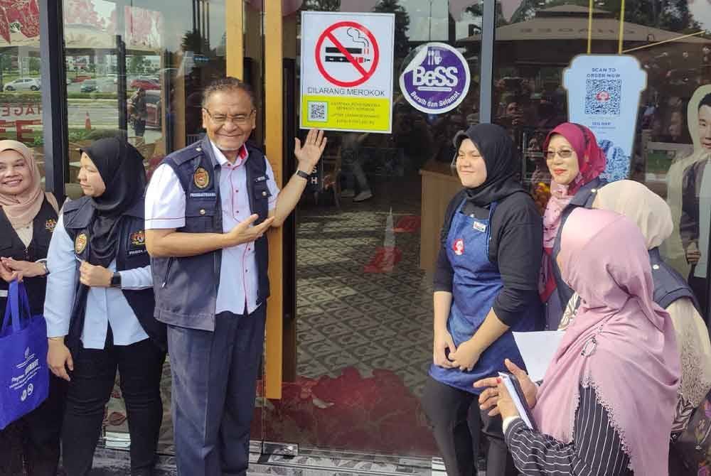 Dzulkefly (tiga dari kiri) bergambar selepas menampal poster larangan merokok di salah sebuah premis semasa melakukan tinjauan Premis Bersih, Bebas Asap Negeri Selangor di Grandeur Labs, Puncak Alam pada Ahad.